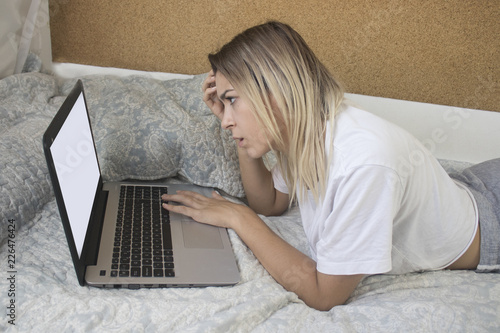 Very young girl with computer in bed photo