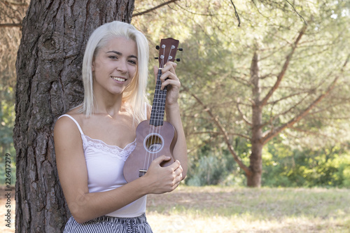 Wallpaper Mural Attractive young woman playing ukulele in the field Torontodigital.ca