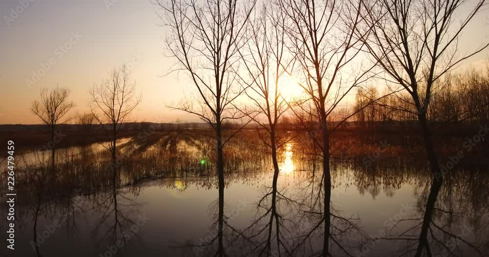 Aerial, beautiful fall landscape on a big pond on sunset with low water and sun reflections Aerial, beautiful fall landscape on a big pond on sunset with low water and sun reflections