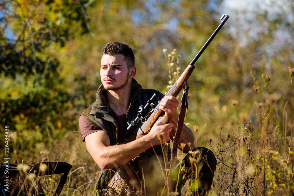 Man hunting wait for animal. Hunting strategy or method for locating targeting and killing targeted animal. Hunting skills and strategy. Hunter with rifle ready to hunting nature background Man hunting wait for animal. Hunting strategy or method for locating targeting and killing targeted animal. Hunting skills and strategy. Hunter with rifle ready to hunting nature background