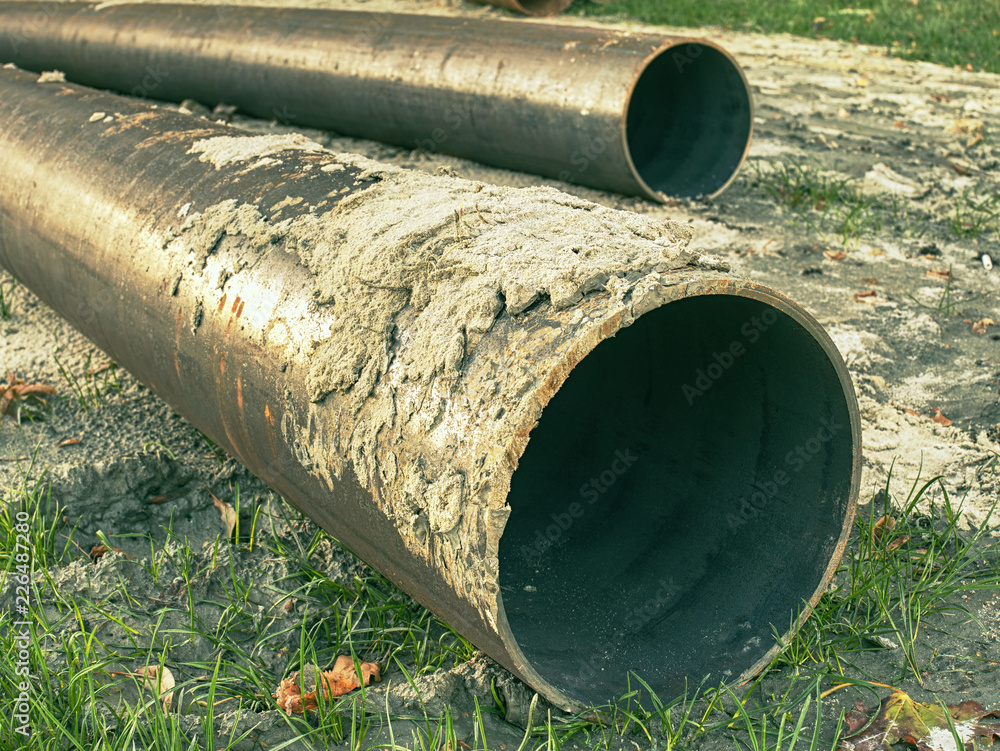 Long metal industrial pipes on ground. Repairing of water system.