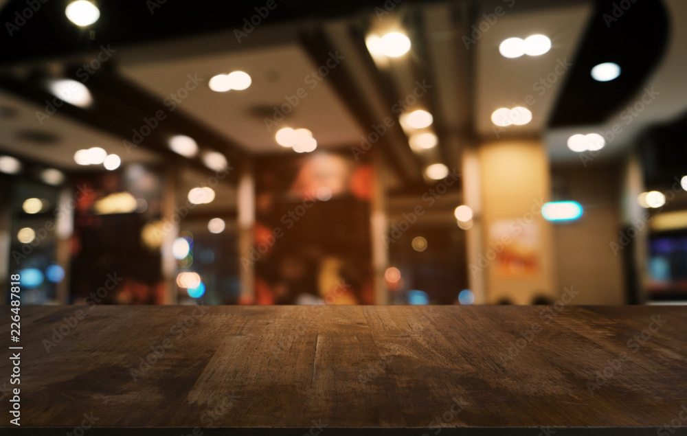 Empty dark wooden table in front of abstract blurred bokeh background of restaurant . can be used for display or montage your products.Mock up for space.