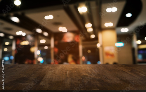 Empty dark wooden table in front of abstract blurred bokeh background of restaurant . can be used for display or montage your products.Mock up for space.