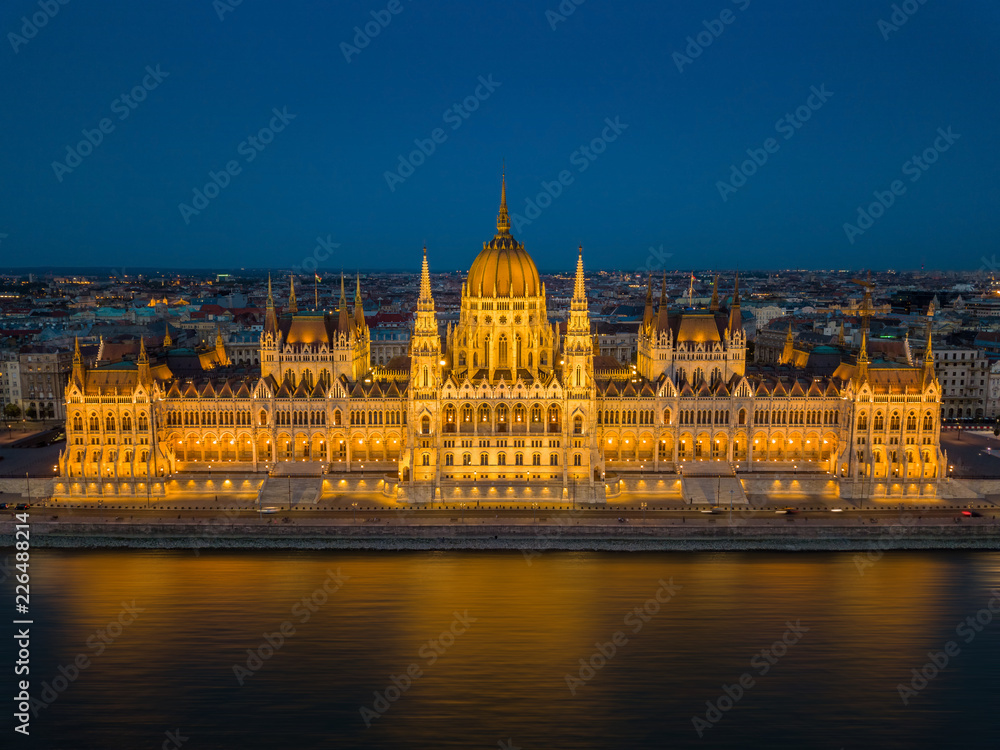 Budapest, Hungary - Aerial view of the beautiful illuminated Parliament of Hungary (Orszaghaz) at blue hour with clear blue sky