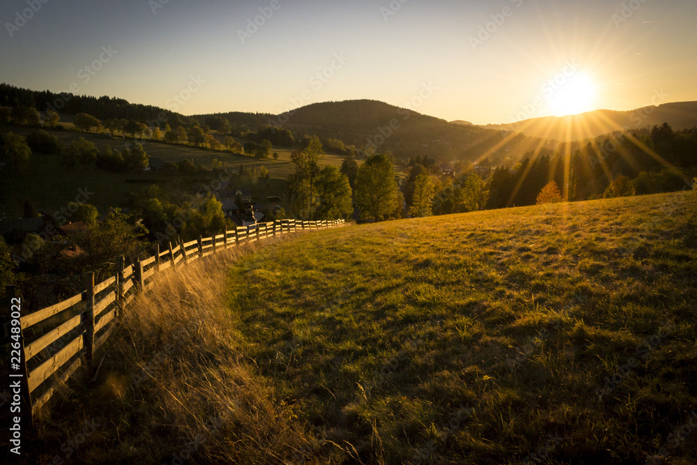 Beautiful evening morning country meadow in Krkonoše national park with mountains at sunrise at sunset