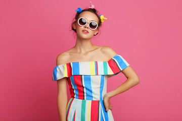 Fashion cool girl posing on pink background.
