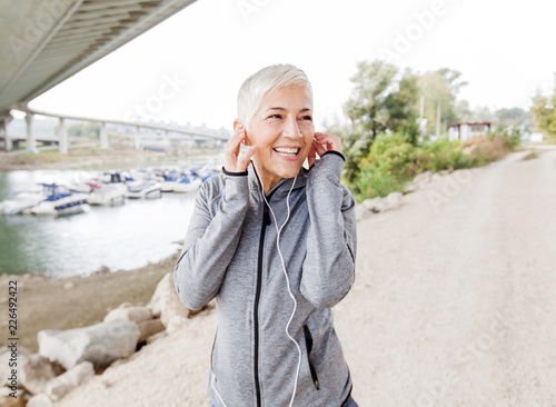 Happy Mature Woman Relax Listening Music With Earphones After Jogging