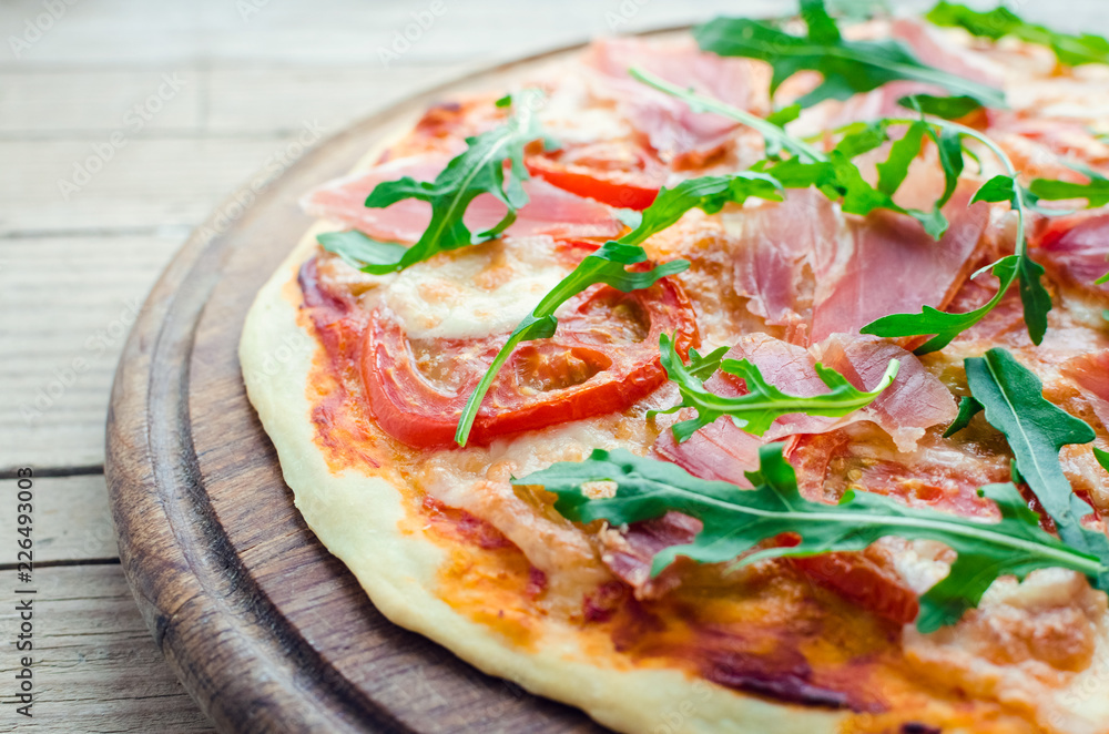 Italian pizza with prosciutto and arugula Italian pizza with prosciutto and arugula