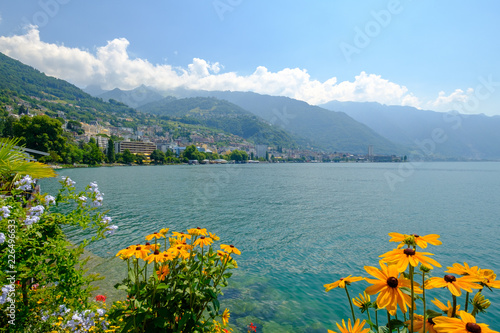 View to Montreux city from Geneva  lake embankment at sunny summer day, flowers at foreground.  photo