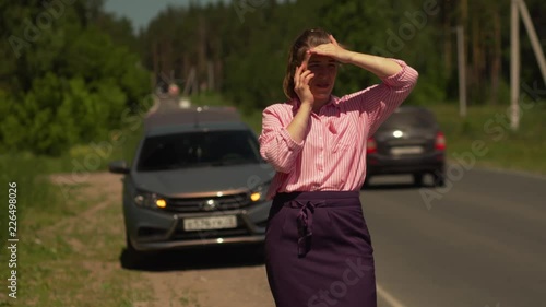 Upset Pretty Young Woman Talking On The Phone With The Evacuator Service Asking For Help To Pick Up Her Suddenly Broken Car On The Track In The Forest.