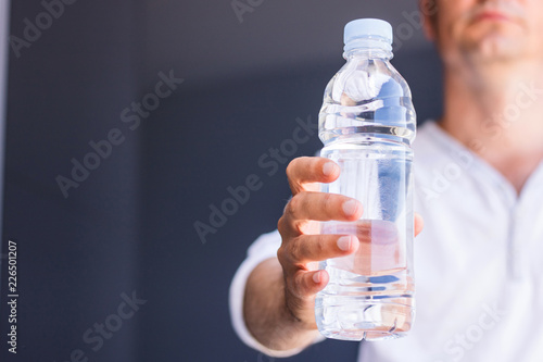 Unrecognizable man holding bottle of water.