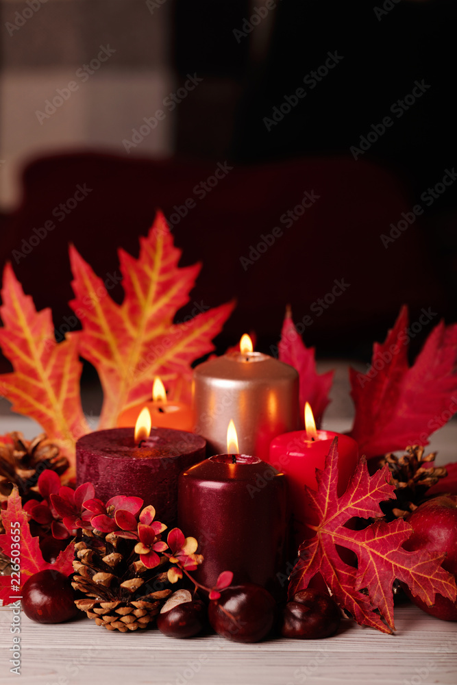 Autumn still life - candles, leaves and cones on the background of pillows. Autumn still life - candles, leaves and cones on the background of pillows.
