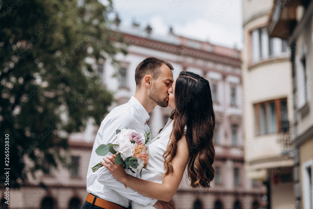 Tender hugs of a wedding couple walking around an old European city