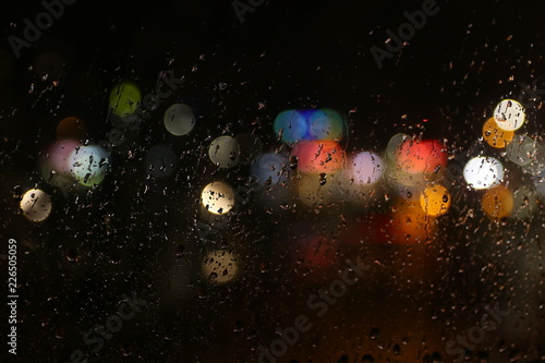 Color lights on the rainy dark window glass