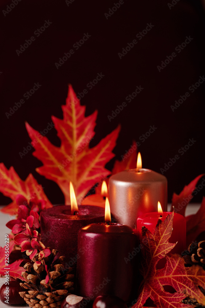 Autumn still life - candles, leaves and cones on the background of pillows. Autumn still life - candles, leaves and cones on the background of pillows.