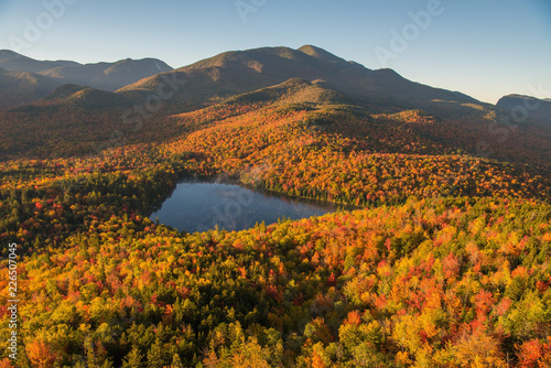 Morning light illuminates the fall color in the Adirondack Mountains over Heart Lake photo