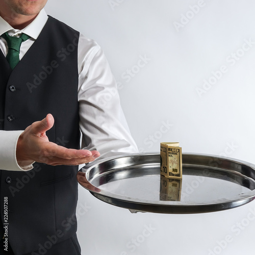 Butler / waiter holds a sil...