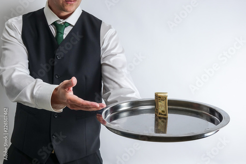 Butler / waiter holds a sil...