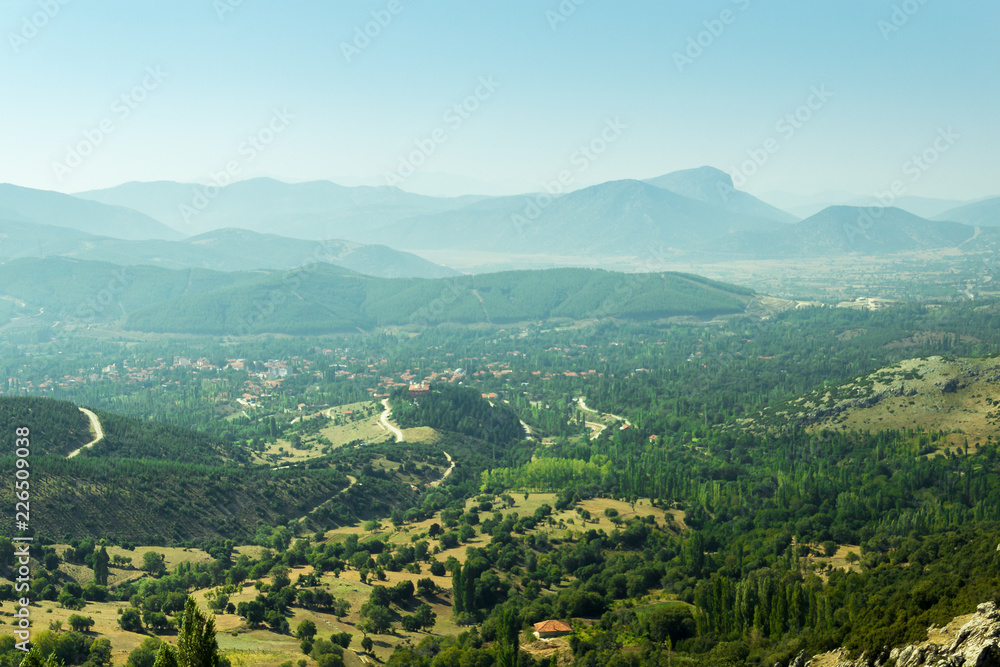 Naklejka premium Beautiful view of mountains in fog, evergreen woods