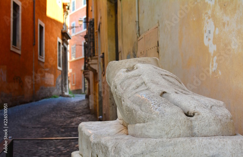 The marble foot of a colossal Roman statue in an alley in Rome, Italy