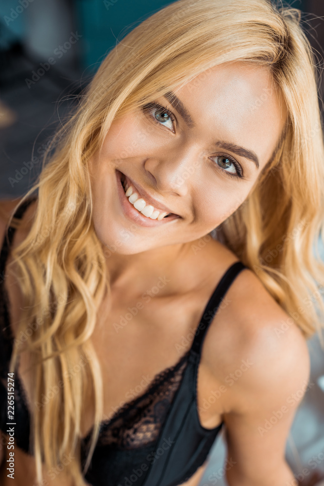 portrait of attractive smiling woman in black lingerie looking at camera in bedroom portrait of attractive smiling woman in black lingerie looking at camera in bedroom