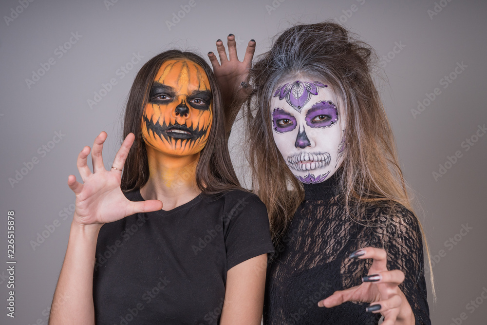 Young girls with horrific faces of the dead in honor of the holiday of Halloween Young girls with horrific faces of the dead in honor of the holiday of Halloween
