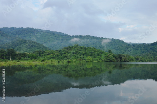 landscape of tree and reflection on water surface in lake with mountain background