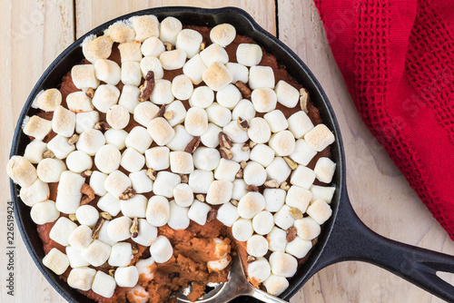 Homemade sweet potato casserole with marshmallows and pecans.
