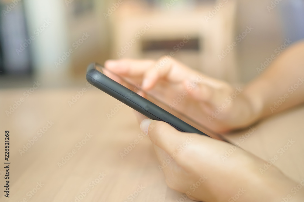 Woman hand using smartphone and laptop with cafe shop sunlight shade to object beautiful background. Woman hand using smartphone and laptop with cafe shop sunlight shade to object beautiful background.