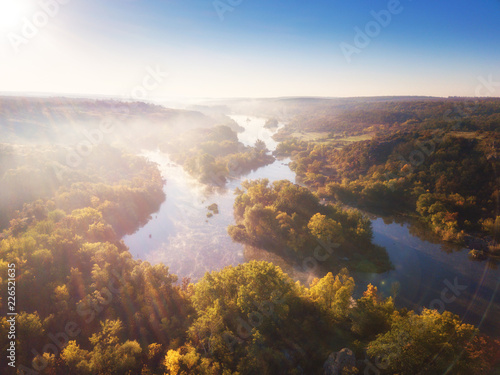 Aerial view of the river and color trees, sunny autumn landscape, drone shot. National park Bugski Guard with picturesque valley and Southern Bug river, Mykolaiv region, Ukraine
