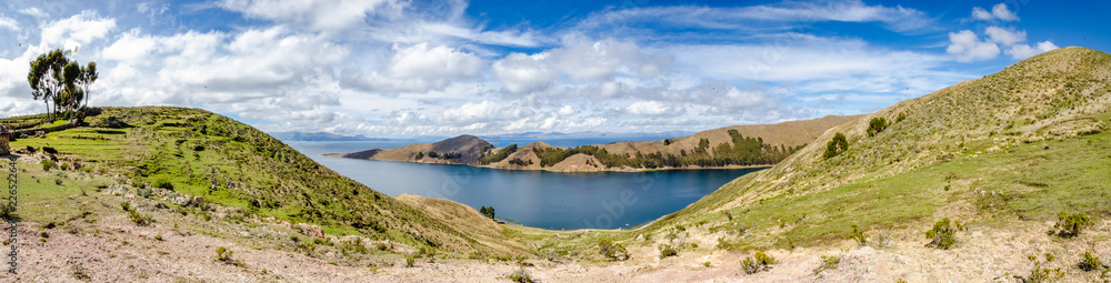 Panoramic on Isla del Sol with plantations, road, boats and Titikaka Lake on a sunny day
