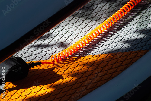 Surfboard closeup, orange leash, paddle standing, photo