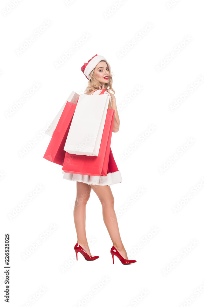 young woman in christmas dress and hat holding shopping bags isolated on white young woman in christmas dress and hat holding shopping bags isolated on white