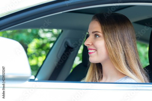Happy young woman in a new luxury car © Tierney