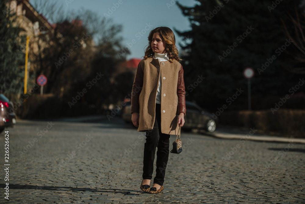 Fototapeta premium Autumn walk on a sunny day. Beautiful young lady