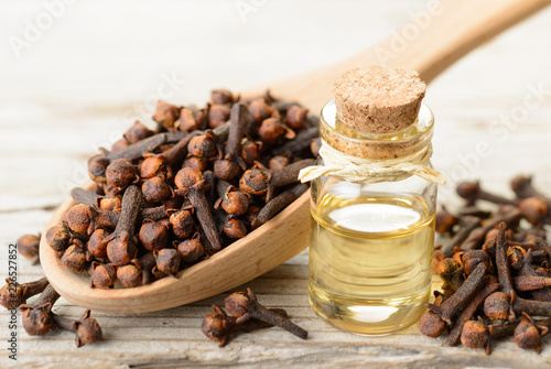 Εκτύπωση καμβά clove essential oil in the glass bottle, on the wooden board