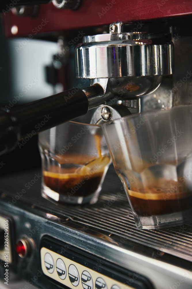 close-up view of professional coffee machine and two glasses with espresso close-up view of professional coffee machine and two glasses with espresso