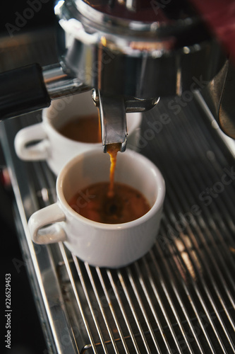 close-up view of coffee maker and two cups with espresso