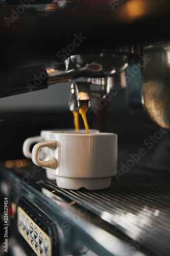 close-up view of coffee machine and two cups with espresso