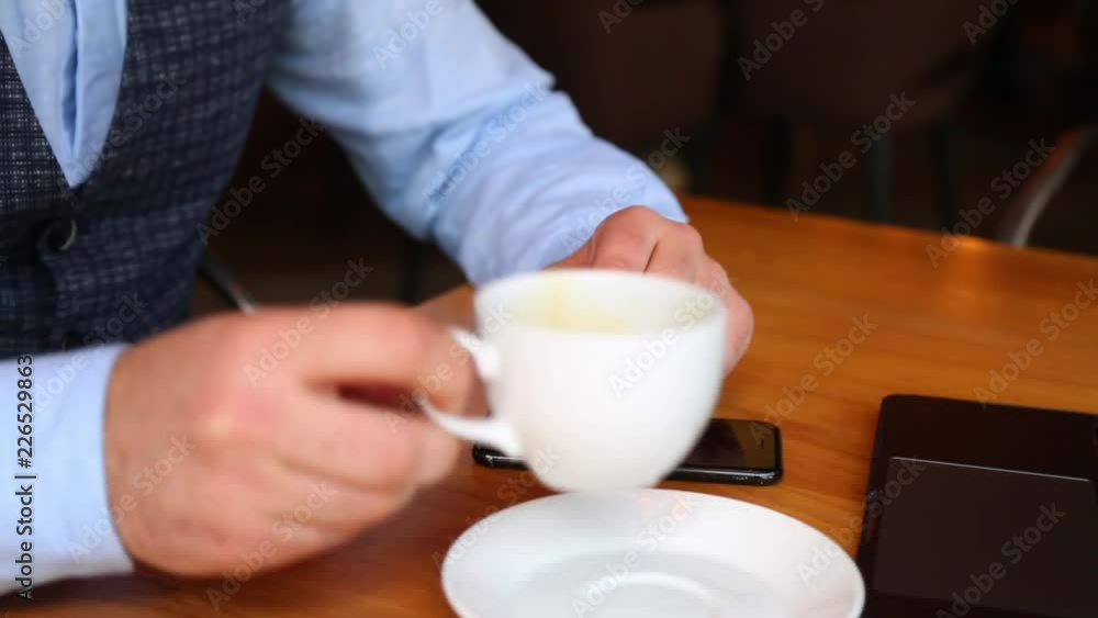 Waiter in a restaurant brings bill to table for man. Man making payment through NFC technology on mobile phone in cafe. Waiter in a restaurant brings bill to table for man. Man making payment through NFC technology on mobile phone in cafe.