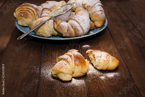 Quadro su tela Ruddy, fresher buns with powdered sugar on a blue ceramic dish.