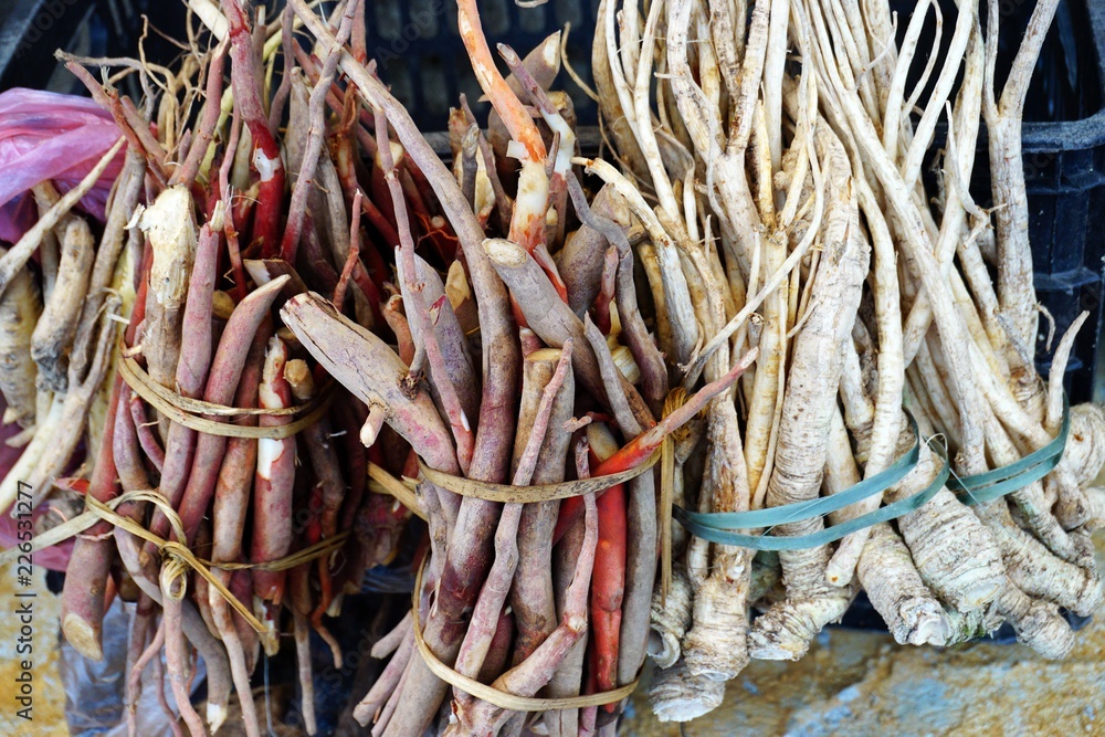 Bundles of natural medicinal roots for sale at a market in Southeast Asia