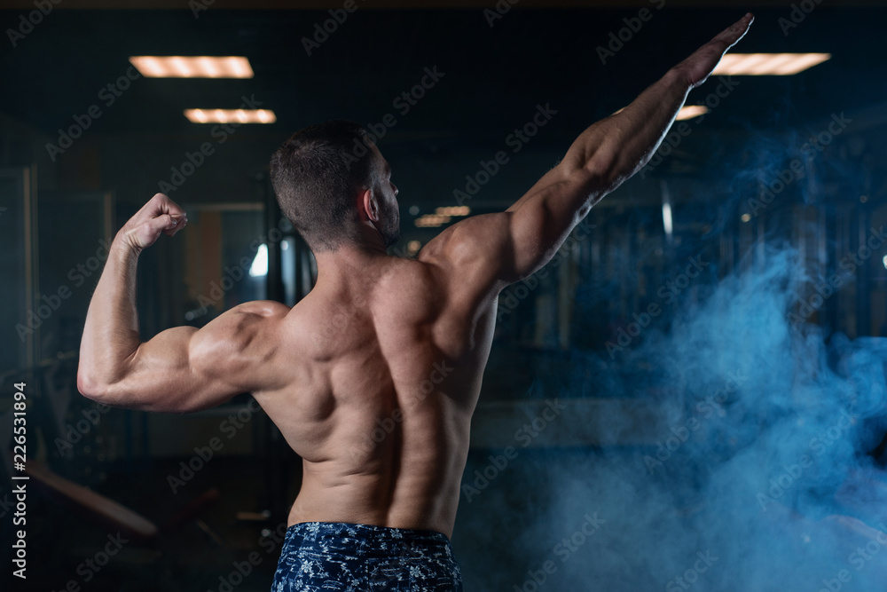 Strong Athletic Man Fitness Model posing back muscles with trice Stock  Photo | Adobe Stock