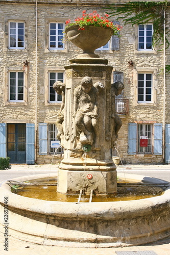 une fontaine sur une place à Barjac