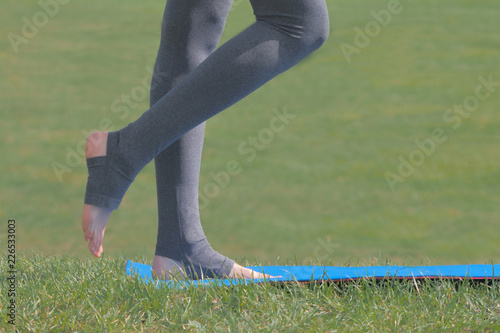 Woman standing on yoga mat and preparing for exercise