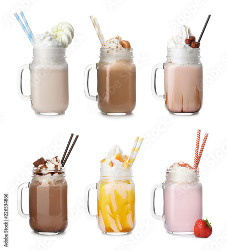 Set with different delicious milk shakes in mason jars on white background