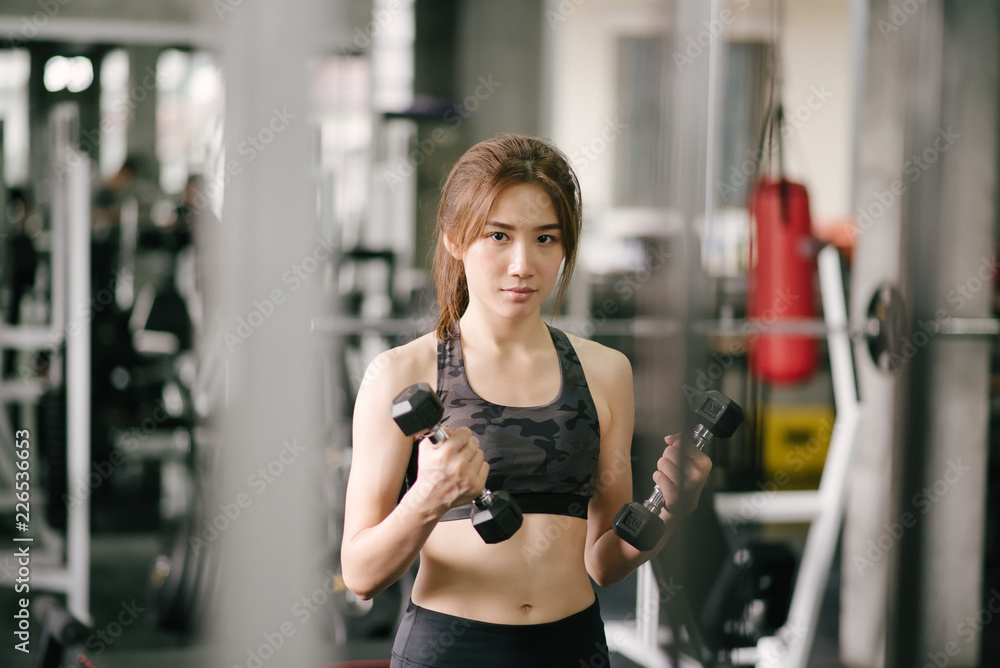 Fitness woman in training exercises with dumbbells. Fitness woman in training exercises with dumbbells.