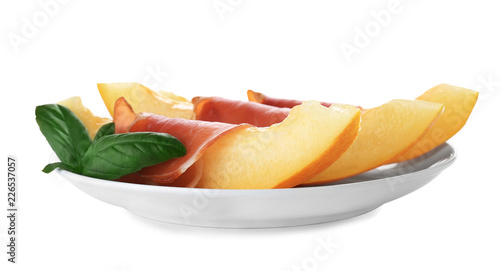 Plate with melon slices and prosciutto on white background