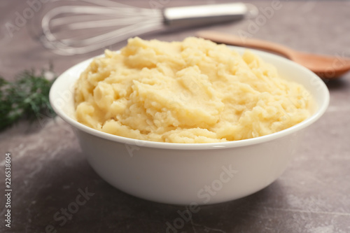 Bowl with mashed potatoes on grey table