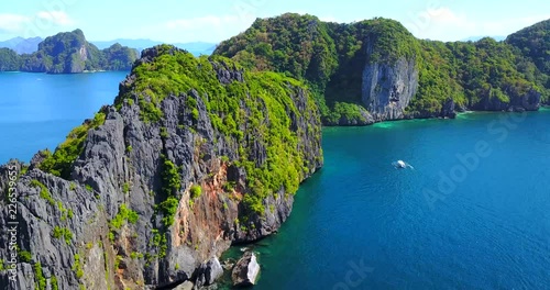 Overhead Approaching View Of Dramatic Rock Cliffs Overlooking Catamaran Boat In Tropical Lagoon Archipelago - El Nido, Palawan, Philippines photo